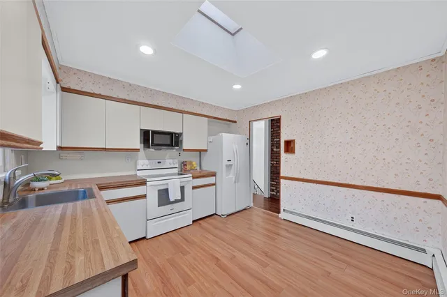 a view of empty room with wooden floor and window