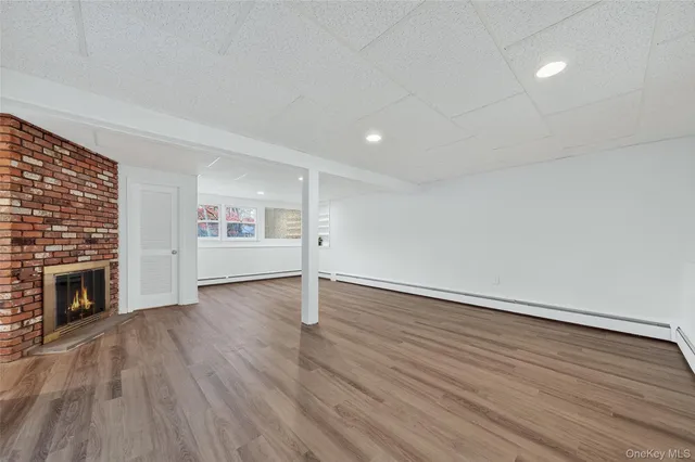 a view of a yard in front of a house with plants and large tree