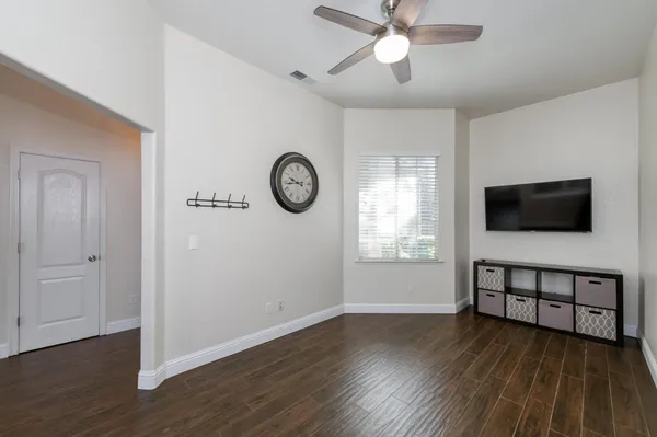 a view of a livingroom with wooden floor and a ceiling fan