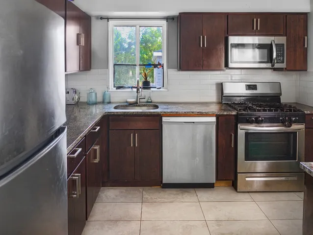 a kitchen with a refrigerator and a counter top space