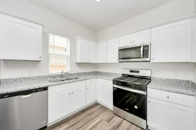 a kitchen with granite countertop a sink and a stove top oven