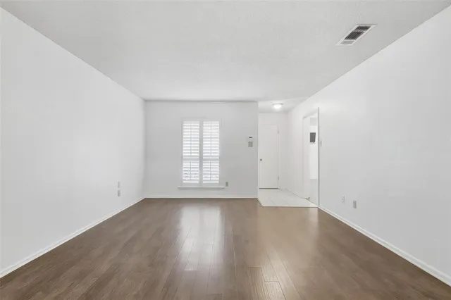 an empty room with wooden floor and window