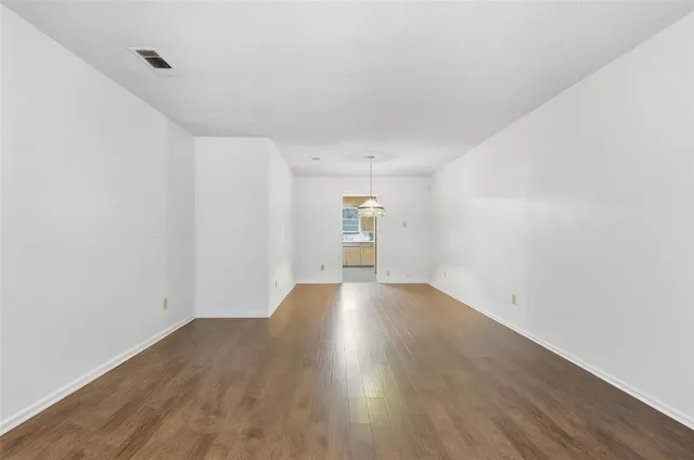 a view of an empty room with a chandelier fan