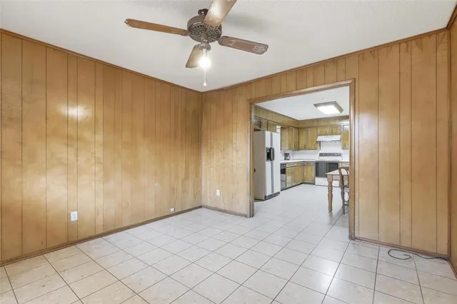 a kitchen with a table chairs refrigerator and cabinets