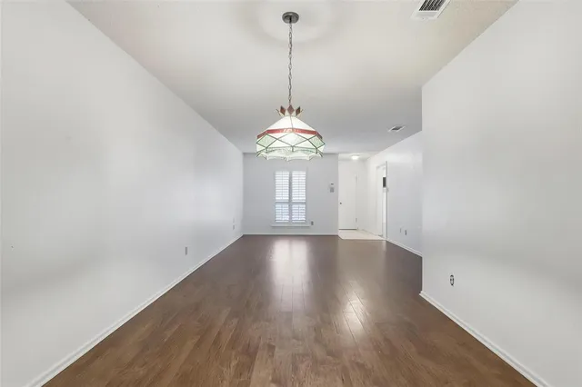 a view of a room with wooden floor and chandelier