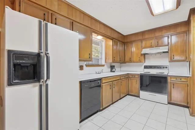 a kitchen with stainless steel appliances granite countertop a refrigerator sink and stove