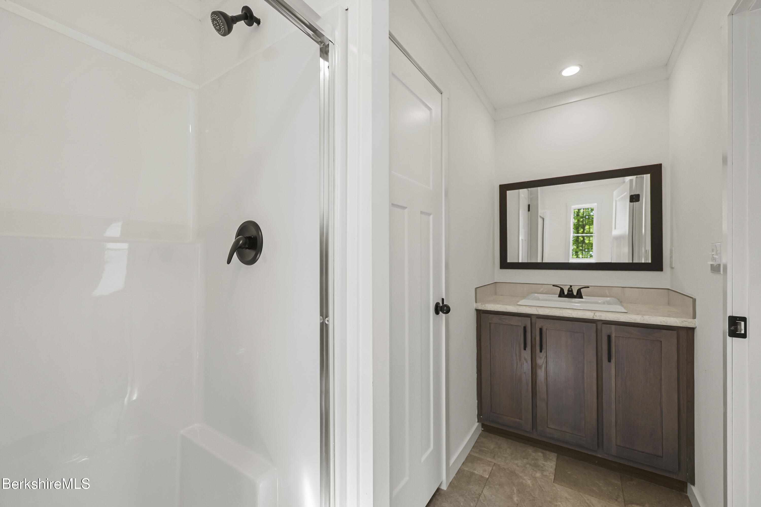 395 Cheshire Road, Unit 112 Pittsfield, MA 01201 - Photo 23 of 32 a bathroom with a sink and mirror with shower