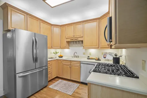 a kitchen with stainless steel appliances granite countertop a refrigerator and a sink