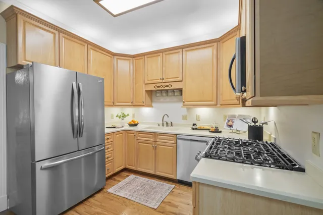 a kitchen with stainless steel appliances granite countertop a refrigerator and a sink
