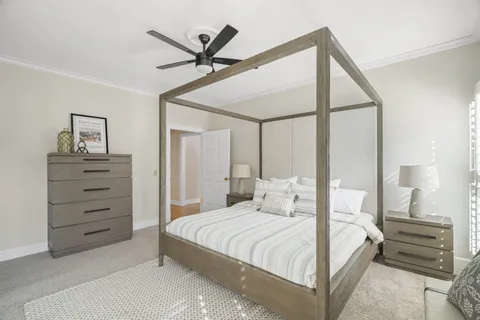 a bedroom with a bed a chandelier and a painting on the wall