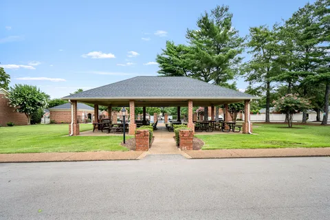 a outdoor space with lots of tables a chairs and iron fence
