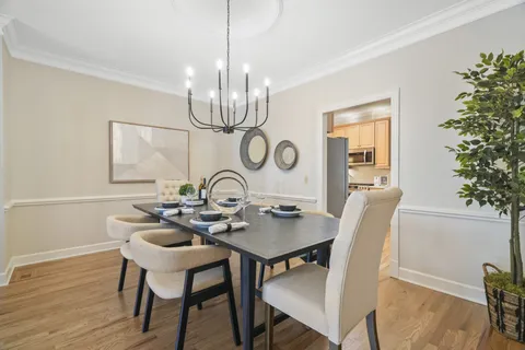 a view of a dining room with furniture wooden floor and chandelier