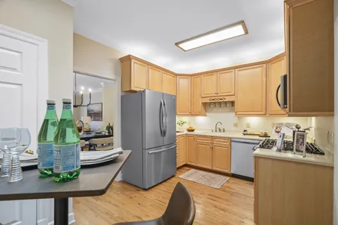 a kitchen with a sink a refrigerator and wooden floor
