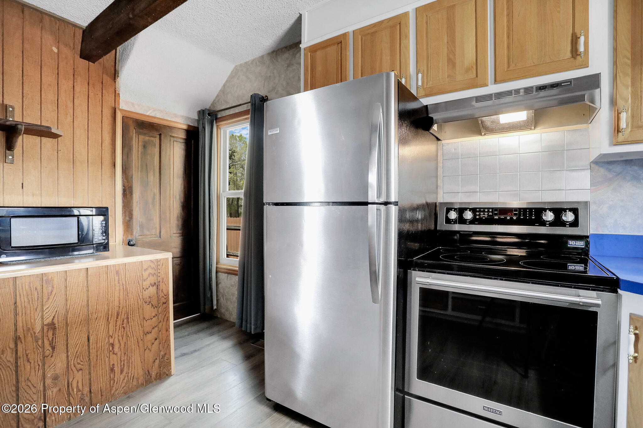 595 Colorado Street Craig, CO 81625 - Photo 14 of 31 a kitchen with a refrigerator stove and cabinets