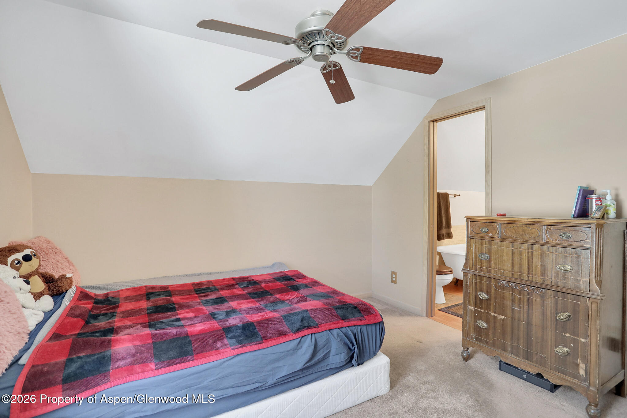 595 Colorado Street Craig, CO 81625 - Photo 20 of 31 a bedroom with a bed and a chandelier