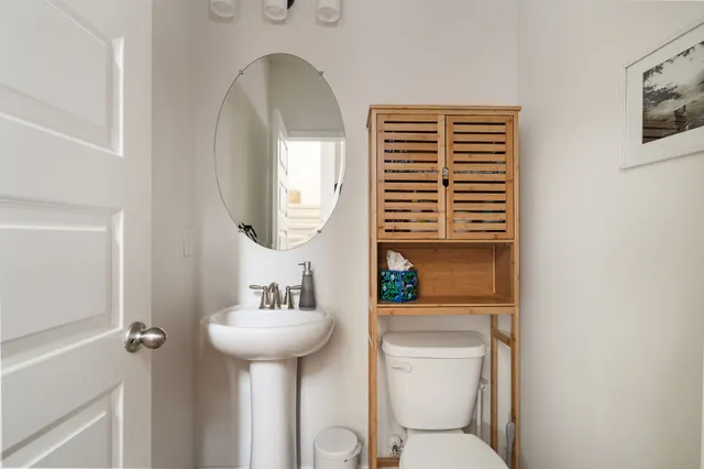 a bathroom with a toilet a sink and a mirror