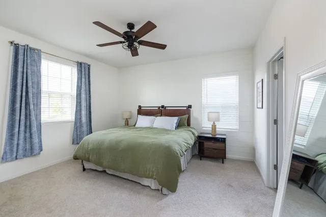 a bedroom with a bed and a ceiling fan