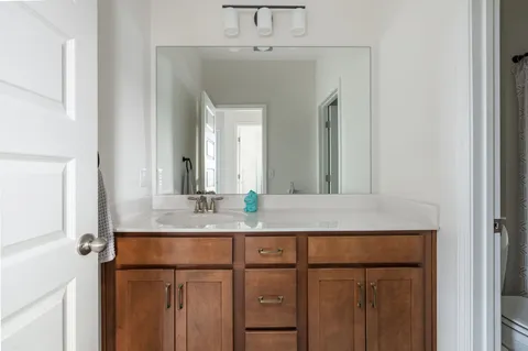 a bathroom with a granite countertop sink and a mirror