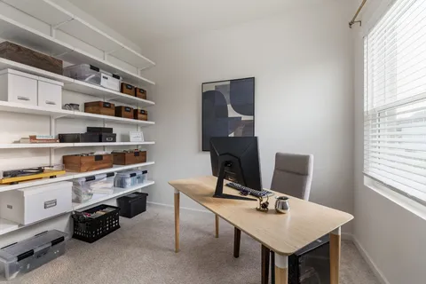 a view of a workspace with furniture and a window