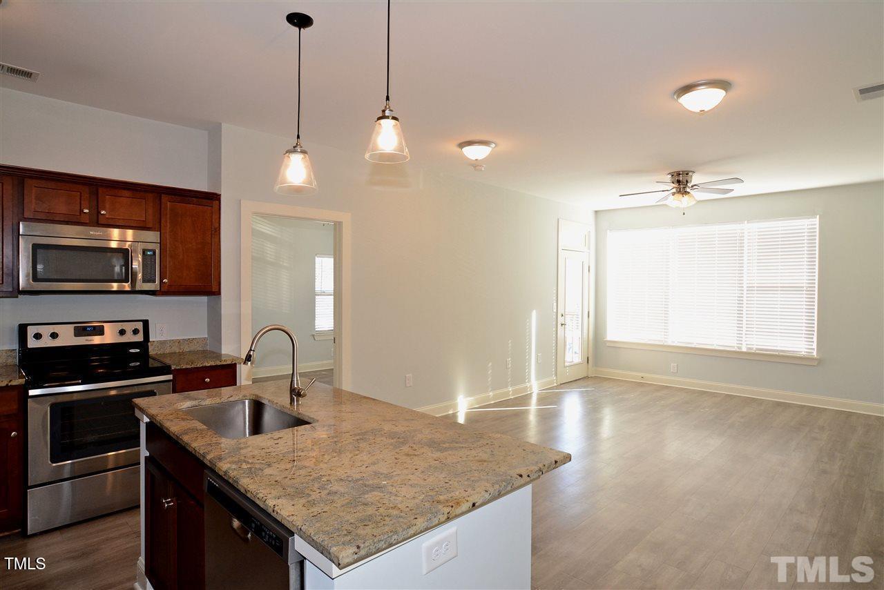 4031 Blackstone Drive, Unit 200 Raleigh, NC 27616 - Photo 3 of 6 a kitchen with stainless steel appliances granite countertop a sink a stove and a refrigerator
