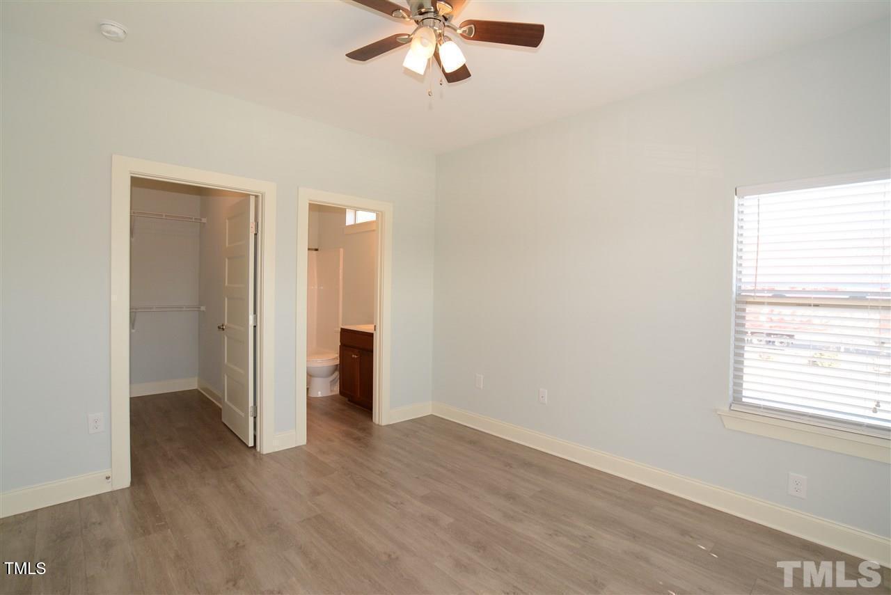 4031 Blackstone Drive, Unit 200 Raleigh, NC 27616 - Photo 5 of 6 an empty room with wooden floor chandelier fan and windows