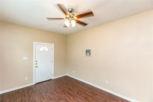 an empty room with a ceiling fan and wooden floor