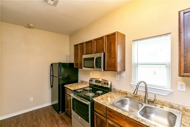 a kitchen with stainless steel appliances granite countertop a sink stove and refrigerator