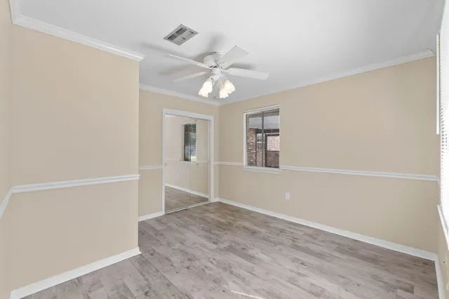 an empty room with windows and fan