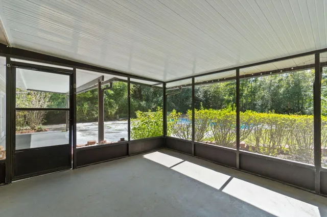 a view of an empty room with wooden floor and doors