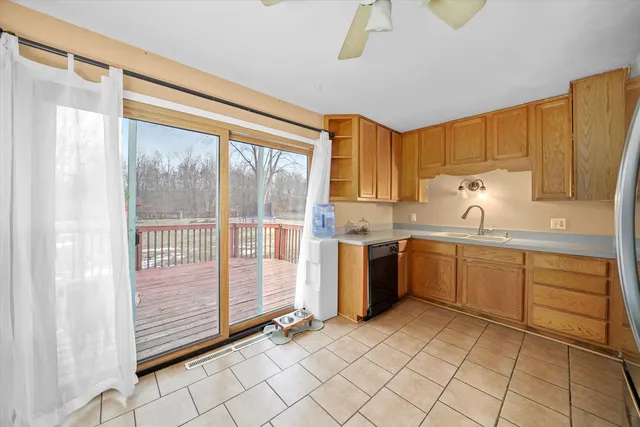 a kitchen with a refrigerator a sink and dishwasher with a large window
