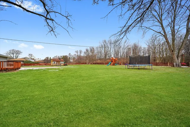 a backyard of a house with lots of green space and fountain