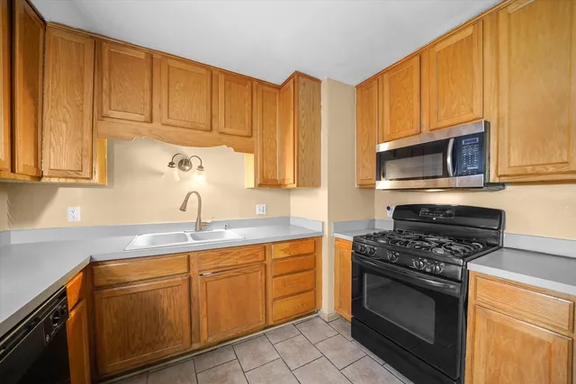 a kitchen with stainless steel appliances granite countertop a sink stove and microwave