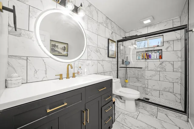 a bathroom with a sink mirror vanity and toilet