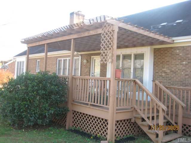 3908 Littlefield Court Raleigh, NC 27606 - Photo 2 of 25 EXTERIOR BACK WITH LARGE DECK W/ LATTICE ACCENT AND PATIO