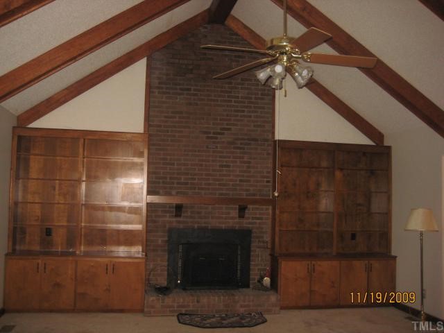 3908 Littlefield Court Raleigh, NC 27606 - Photo 3 of 25 FAMILY ROOM WITH VAULTED CEILING, WOOD STOVE AND BUILT-IN BOOK SHELVES