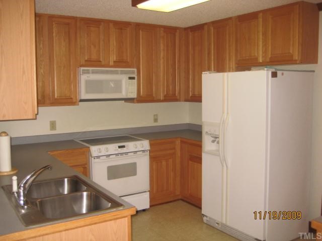 3908 Littlefield Court Raleigh, NC 27606 - Photo 6 of 25 LARGE KITCHEN WITH SMOOTH TOP RANGE, MW, DISHWASHER, BUILT-IN DESK, 42" CABINETS AND CUSTOM BUILT PANTRY.