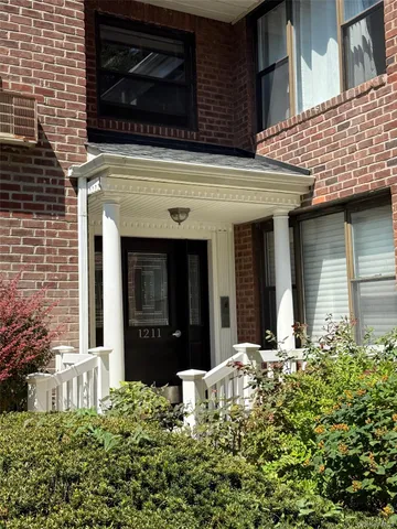a view of brick house with potted plants