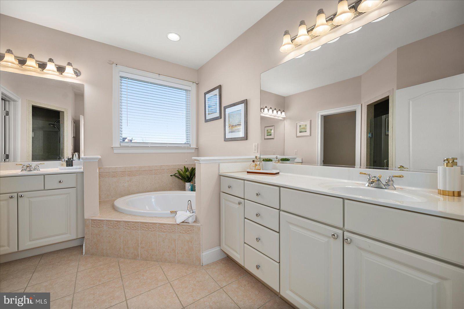 12901 Old Bridge Road, Unit PH8 2 Ocean City, MD 21842 - Photo 31 of 79 a bathroom with a tub a sink double vanity and a mirror