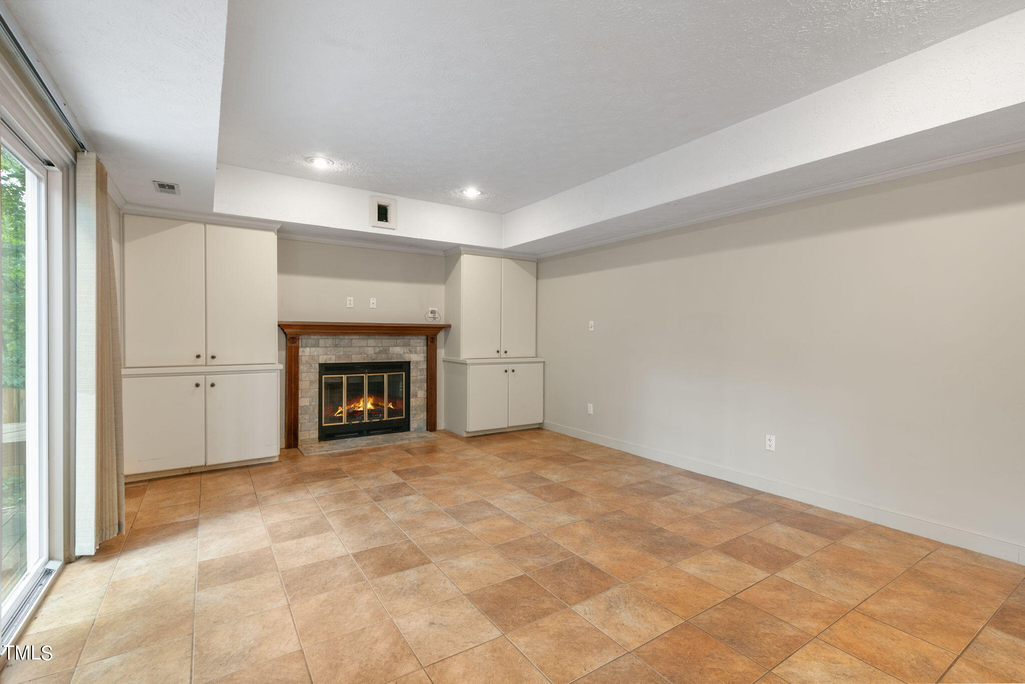 102 Old Bellows Court Raleigh, NC 27607 - Photo 16 of 36 a view of an empty room with a fireplace and a window
