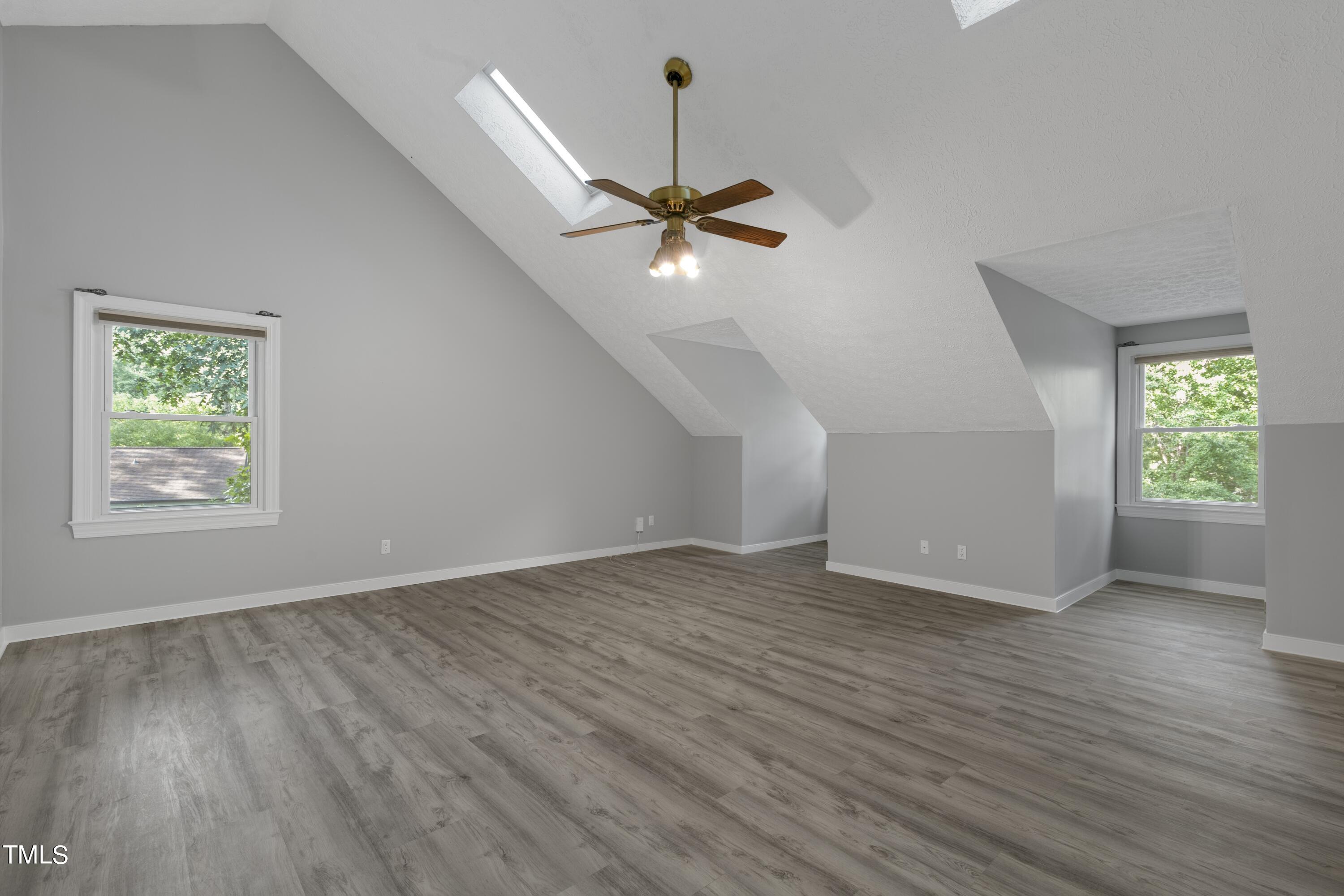 102 Old Bellows Court Raleigh, NC 27607 - Photo 21 of 36 an empty room with wooden floor chandelier fan and windows