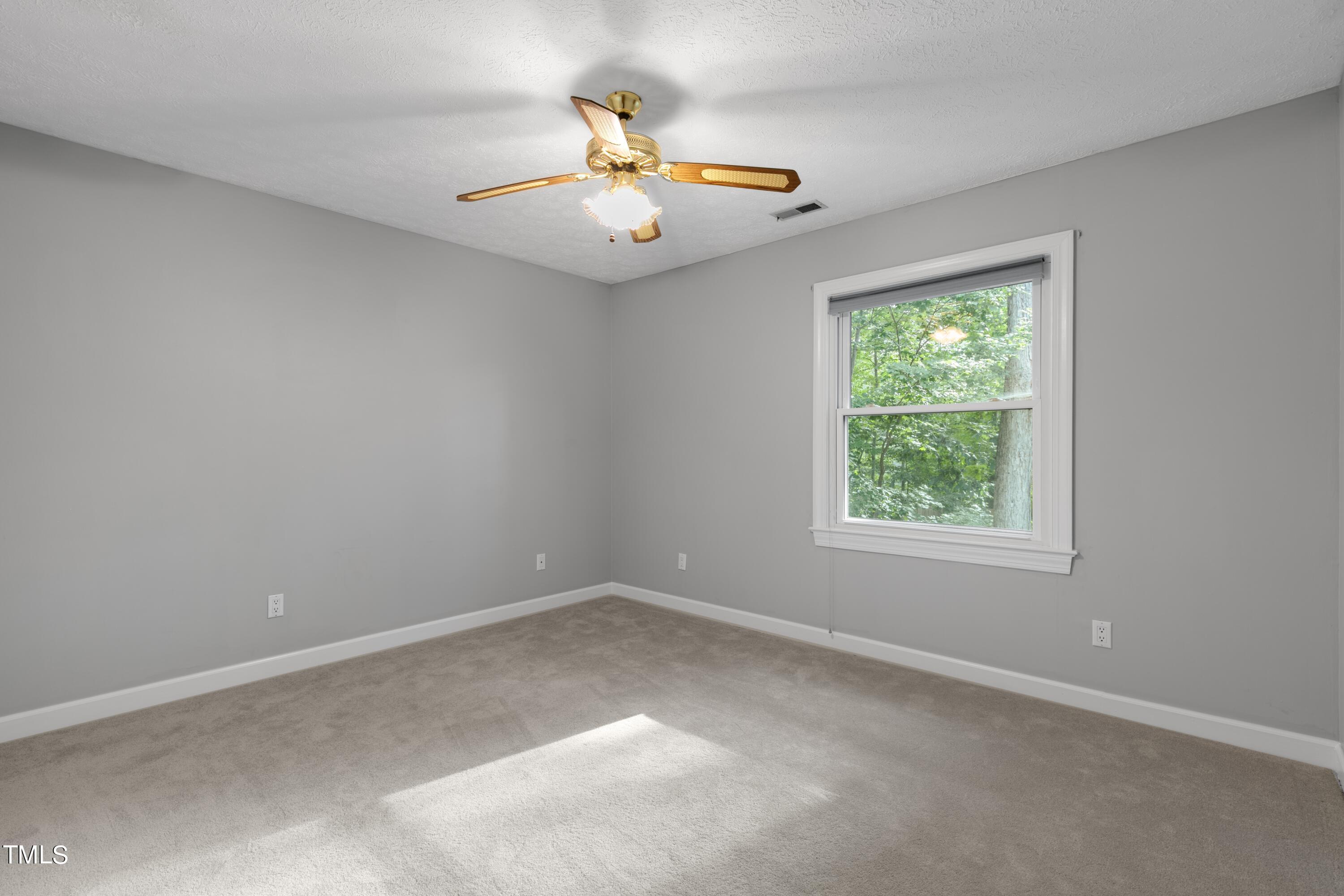 102 Old Bellows Court Raleigh, NC 27607 - Photo 28 of 36 an empty room with a chandelier fan and window