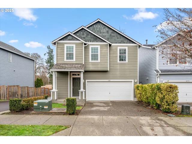 a front view of a house with a yard and potted plants