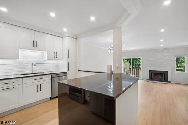 a large kitchen with granite countertop a sink and a stove top oven