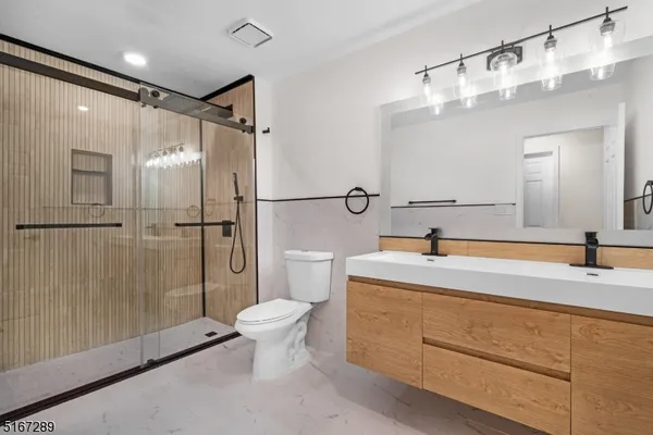 a bathroom with a double vanity sink toilet and shower