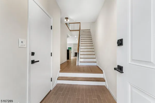 a view of a hallway with wooden floor and entryway