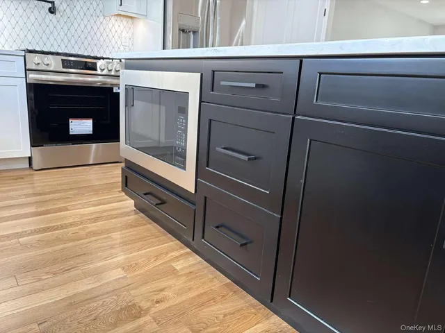 a kitchen with stainless steel appliances granite countertop a sink refrigerator and cabinets