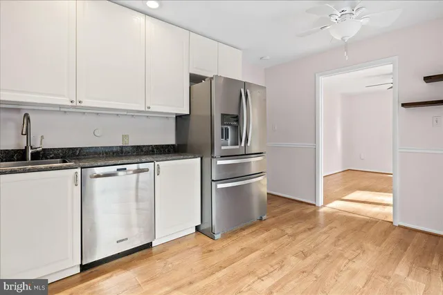 a kitchen with granite countertop a refrigerator and a stove top oven