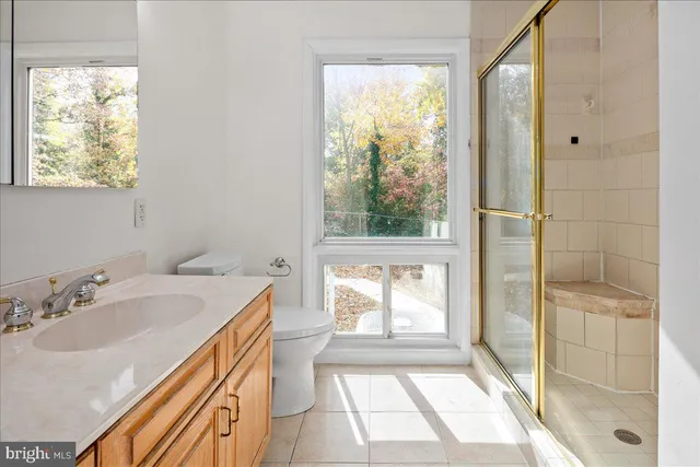 a bathroom with a sink and a large mirror next to a window