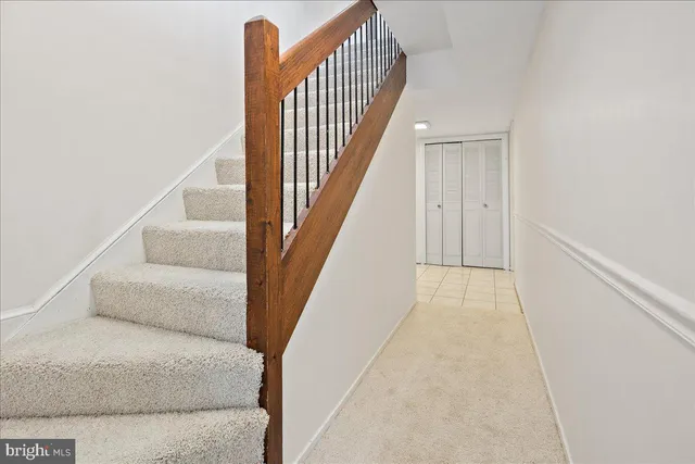 a view of staircase with white walls and railing