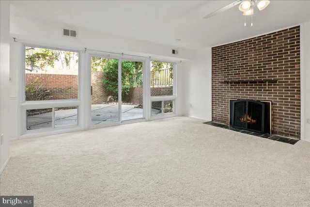 a view of an empty room with a fireplace and a window